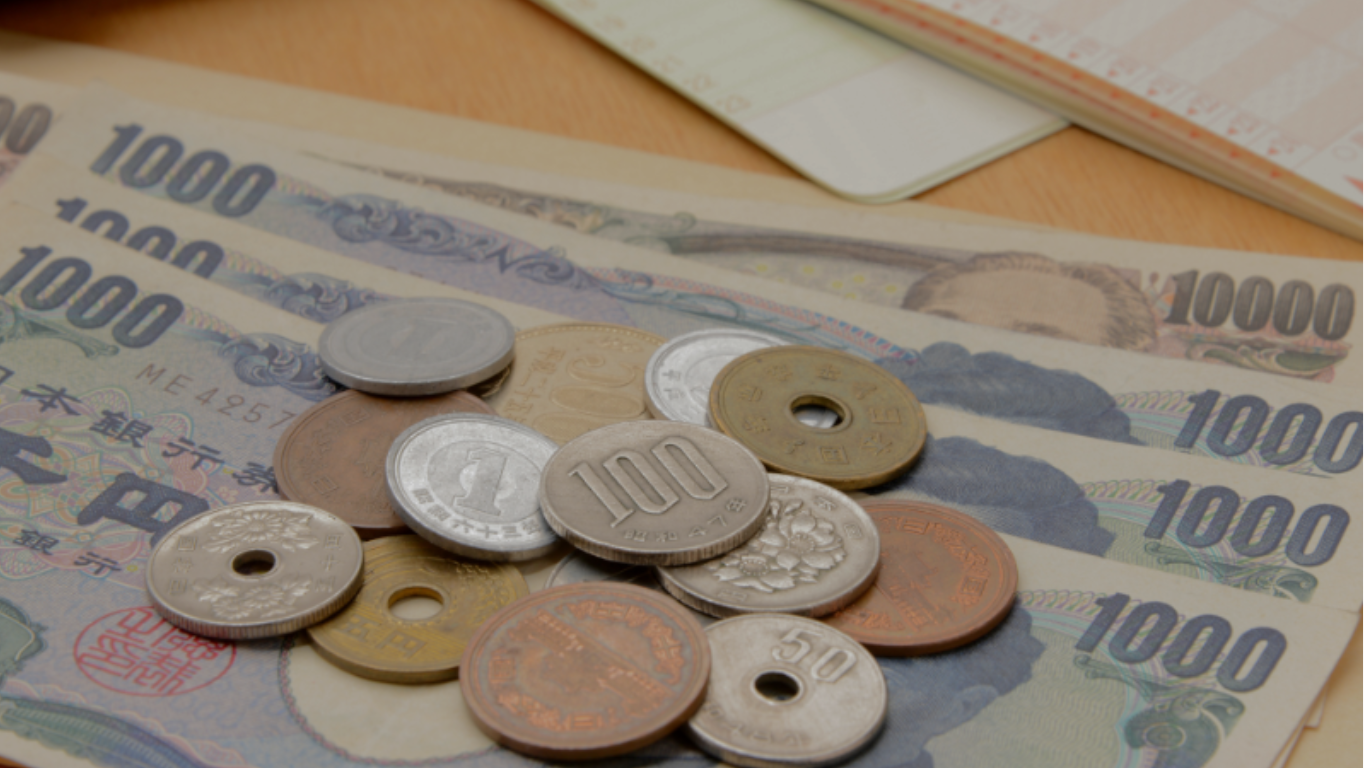 家計管理をイメージした紙幣と硬貨、電卓